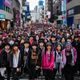 韩国首尔街头K-pop粉丝文化盛况，年轻人身着偶像周边服装聚集，展现东亚娱乐文化活力